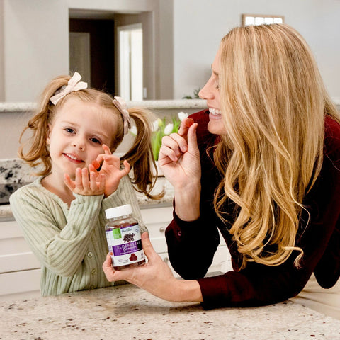 A woman and her child holding Herbion Elderberry Gummies 