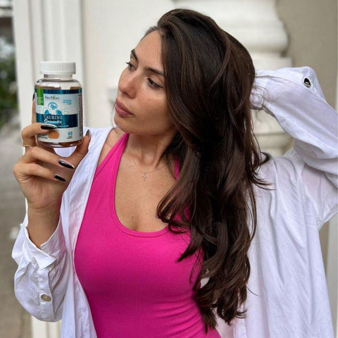 A woman holding Herbion Taurine Gummies with L-Theanine